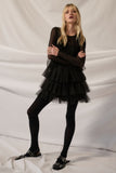 Model wearing a black solid mesh round-neck tulle-layered romper with tights, showcasing a playful yet elegant silhouette.